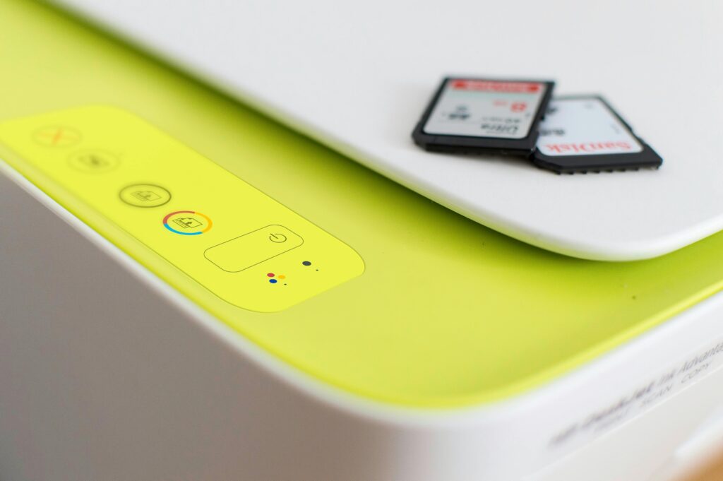 Detailed shot of a printer's control panel with SD cards on top, highlighting modern tech.